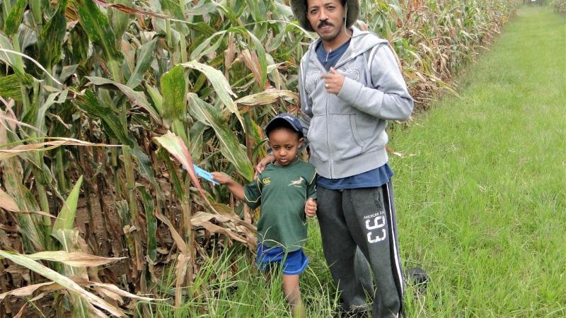 Dr. Girma T. Kassie with his son in the field