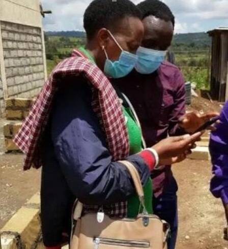Kenyan farmer using weather intelligence on her phone 